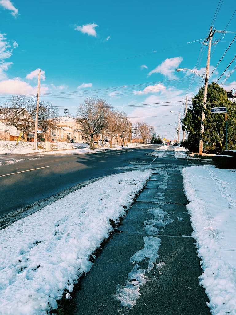Snow-covered street in Toronto, Canada on a clear winter day with blue skies.